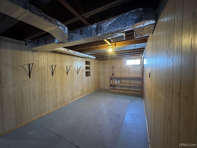 basement featuring wood walls