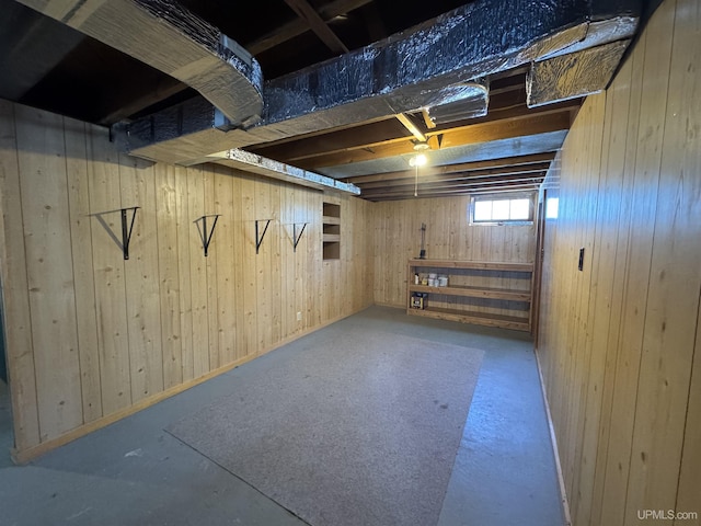 basement featuring wooden walls