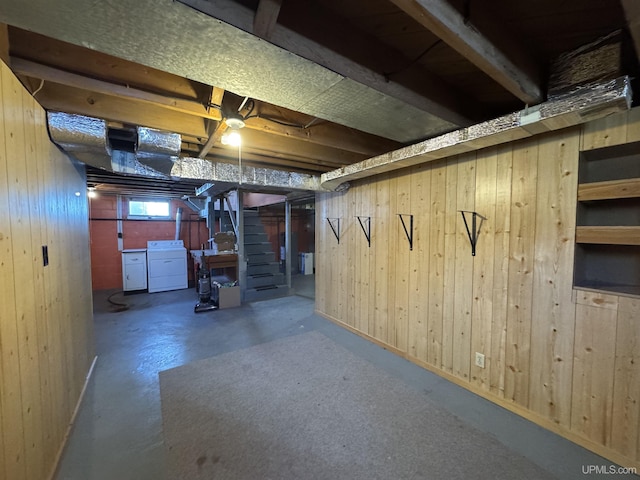 basement with washing machine and dryer and wood walls