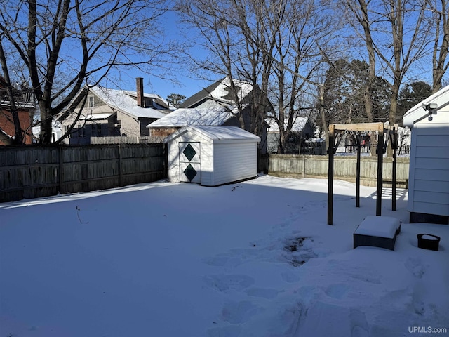 yard layered in snow featuring a shed