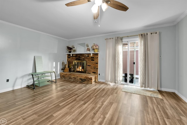 unfurnished living room featuring a brick fireplace, hardwood / wood-style flooring, crown molding, and ceiling fan