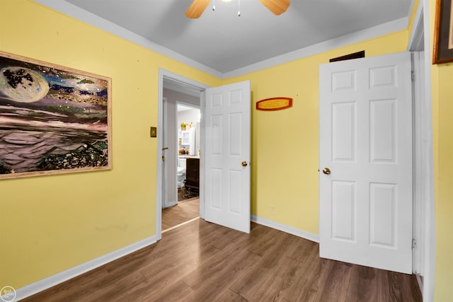 unfurnished bedroom with ceiling fan and dark hardwood / wood-style flooring