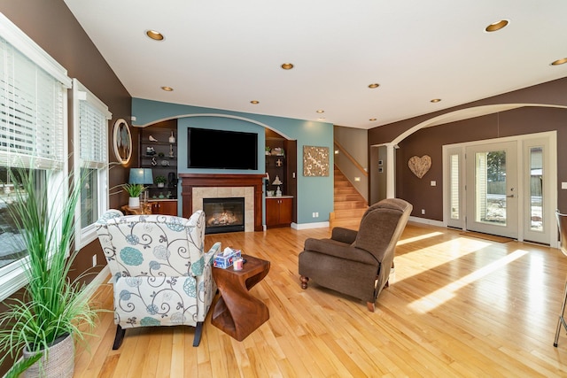 living room featuring light hardwood / wood-style floors and a tiled fireplace