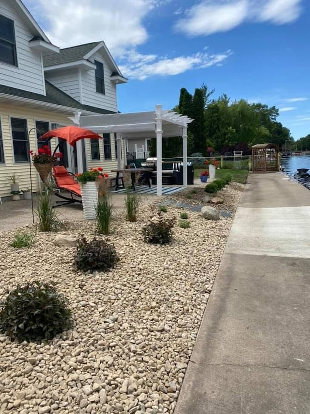 view of yard featuring a patio area, a water view, and a pergola