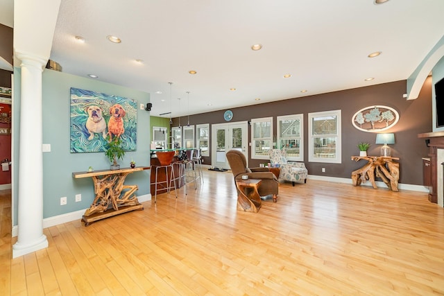 sitting room with decorative columns and light hardwood / wood-style flooring