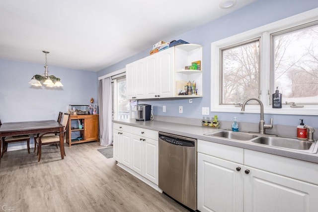 kitchen featuring light hardwood / wood-style floors, white cabinetry, stainless steel dishwasher, sink, and decorative light fixtures