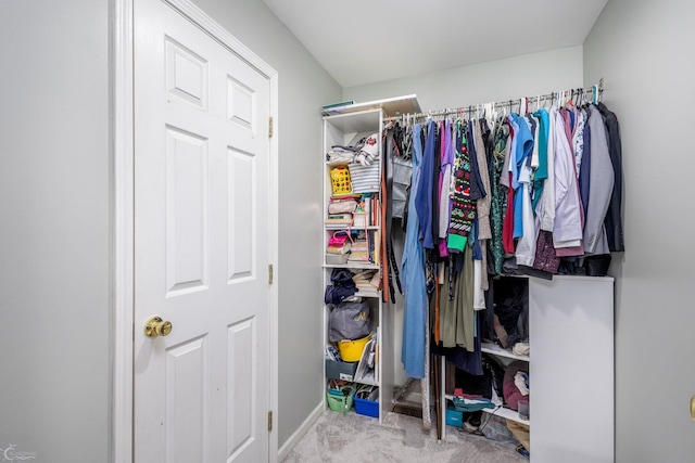 walk in closet featuring light colored carpet