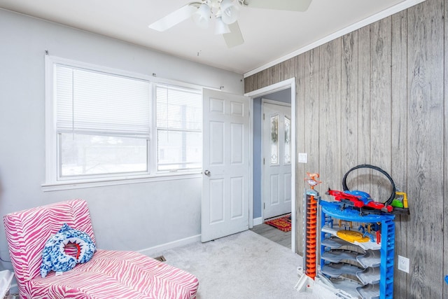 bedroom with ceiling fan, light colored carpet, and wood walls