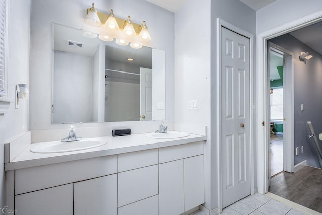 bathroom featuring vanity, a shower, and tile patterned floors