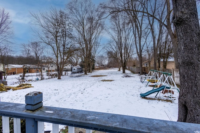 yard layered in snow with a playground