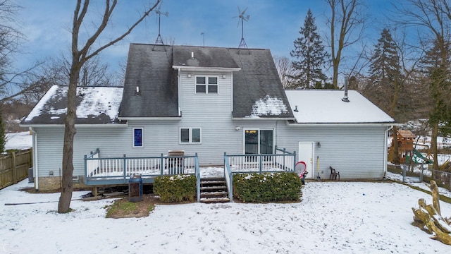 snow covered rear of property featuring a deck