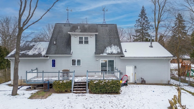 snow covered rear of property with a wooden deck