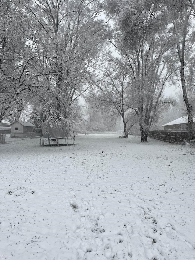 snowy yard featuring a trampoline