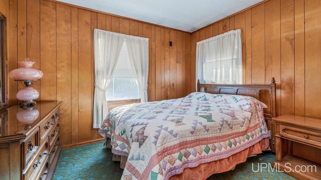 carpeted bedroom featuring wooden walls