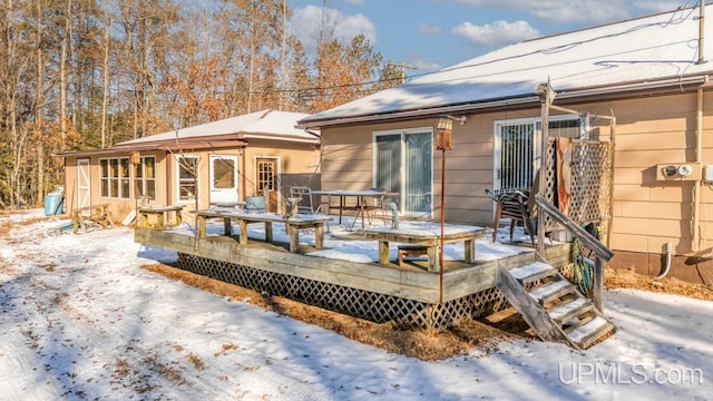 snow covered house featuring a deck