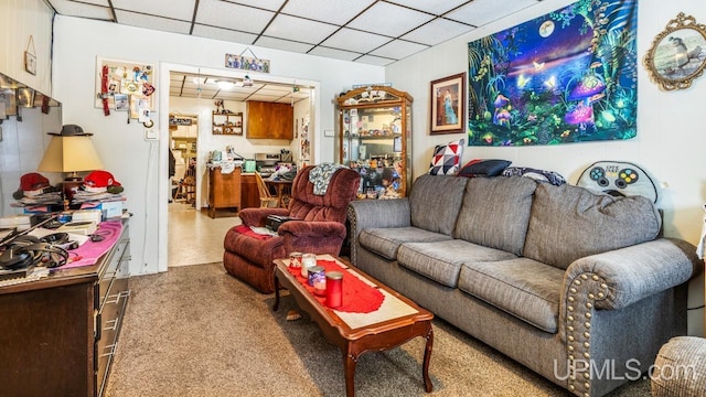 carpeted living room with a drop ceiling