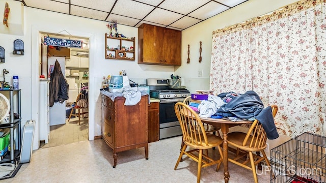 kitchen with a paneled ceiling and gas stove