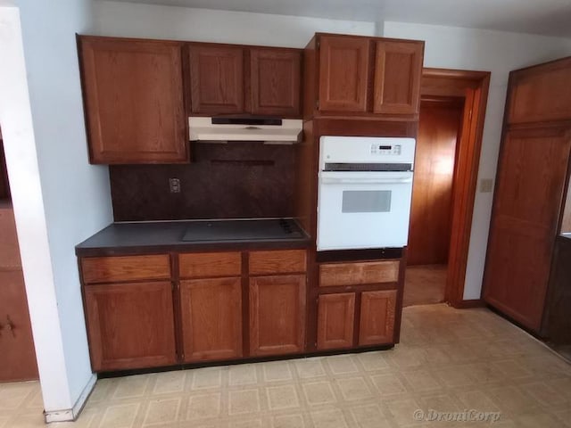 kitchen with black electric cooktop, backsplash, and white oven