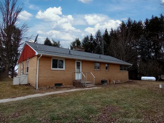 back of property featuring central AC unit and a yard