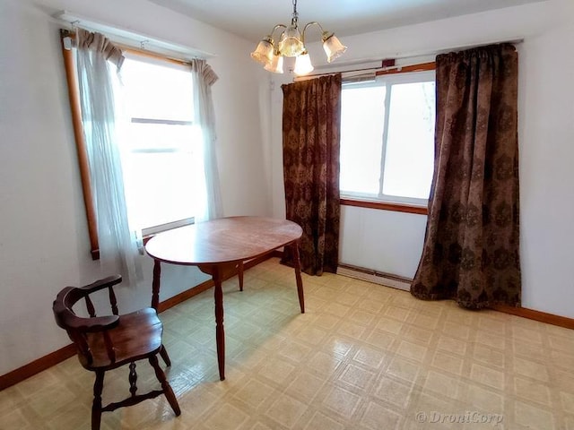 dining space featuring a baseboard radiator and an inviting chandelier