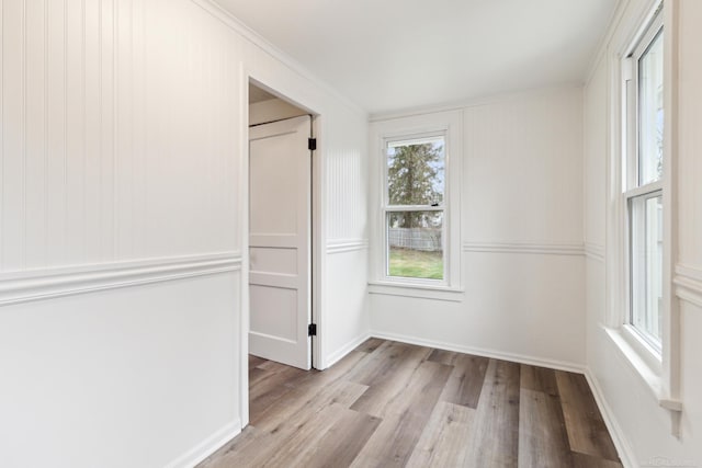 unfurnished room featuring light wood-type flooring and ornamental molding