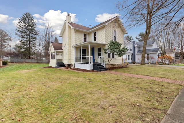 view of side of property featuring covered porch and a yard