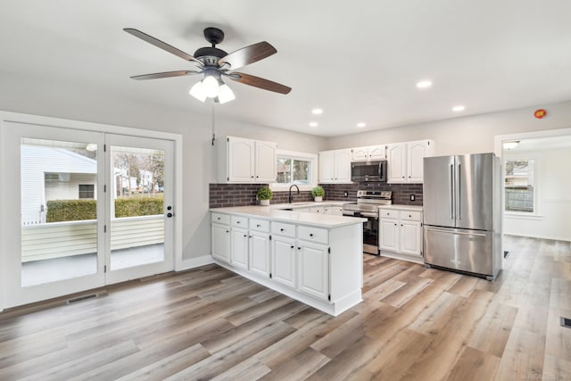 kitchen with white cabinets, stainless steel appliances, backsplash, and sink