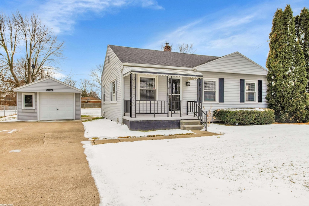 view of front of home featuring a garage, covered porch, and an outdoor structure