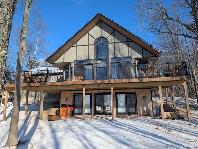 snow covered property with a wooden deck