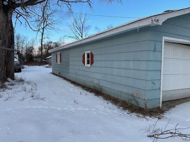 snow covered property with a garage