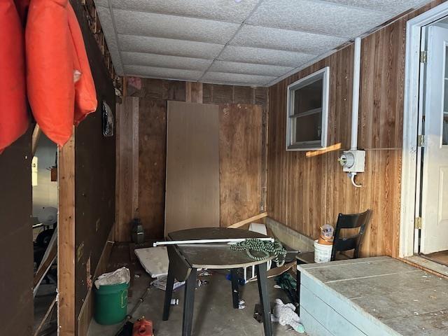 miscellaneous room with wooden walls and concrete flooring