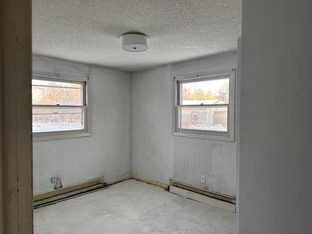 unfurnished room with baseboard heating and a textured ceiling