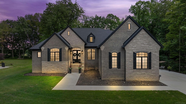 french provincial home with a lawn