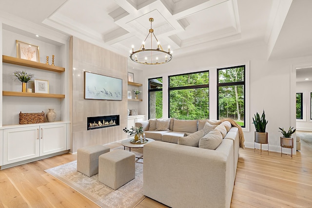 living room with a wealth of natural light, built in features, light hardwood / wood-style flooring, and a fireplace