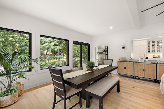 dining area with light hardwood / wood-style floors, plenty of natural light, and beam ceiling