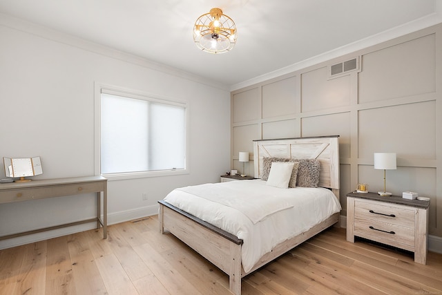 bedroom featuring light hardwood / wood-style flooring and ornamental molding