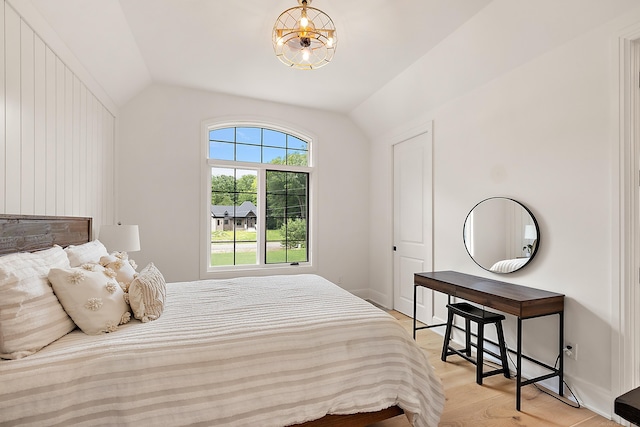 bedroom with light wood-type flooring and vaulted ceiling