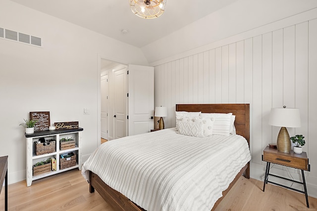 bedroom with hardwood / wood-style floors and lofted ceiling