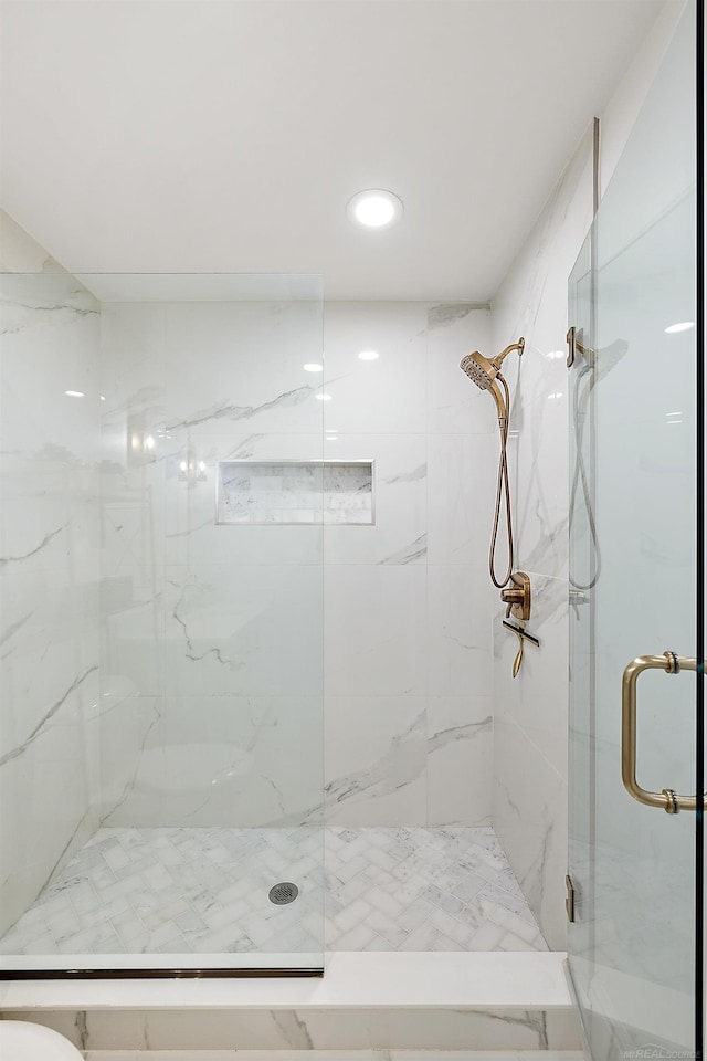 bathroom featuring a shower with door