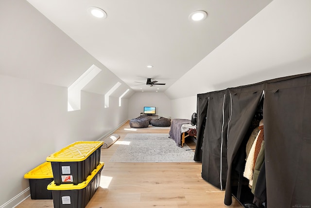 interior space with ceiling fan, lofted ceiling, and light wood-type flooring