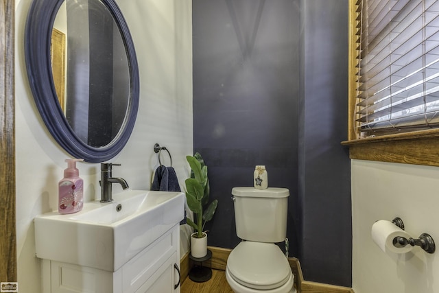 bathroom with vanity, toilet, and wood-type flooring