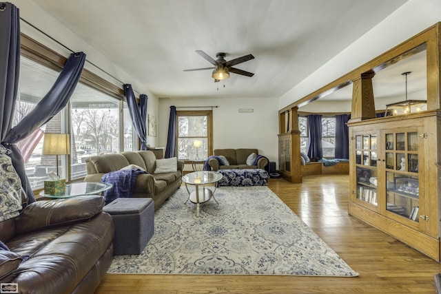 living room featuring hardwood / wood-style flooring, ceiling fan, and ornate columns