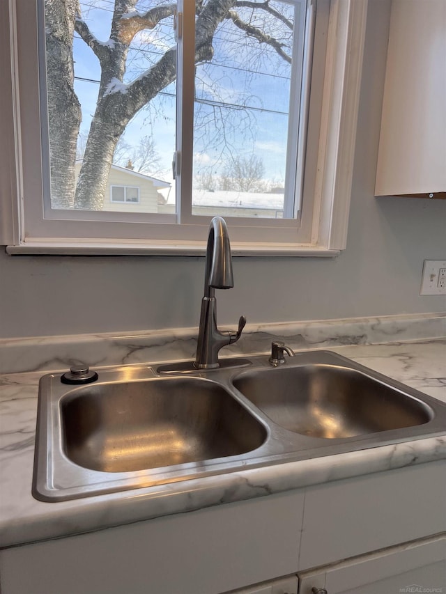 interior details featuring sink and white cabinets