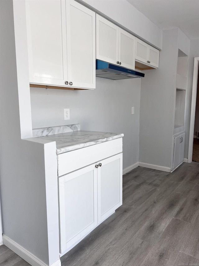 kitchen featuring hardwood / wood-style flooring and white cabinets