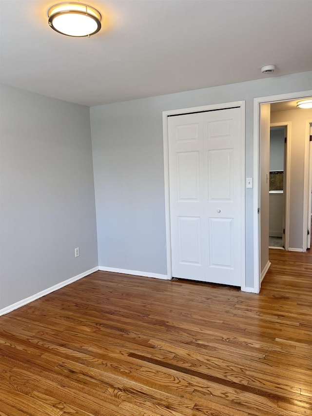 unfurnished bedroom featuring wood-type flooring and a closet