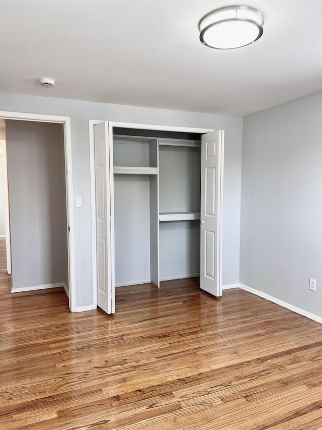 unfurnished bedroom with light hardwood / wood-style floors and a closet