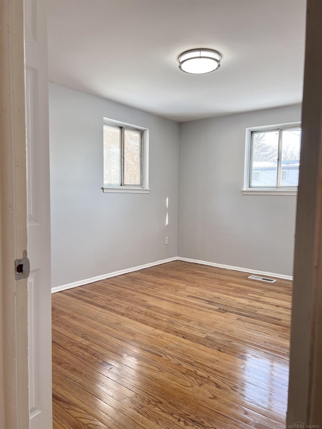 spare room featuring plenty of natural light and light hardwood / wood-style floors