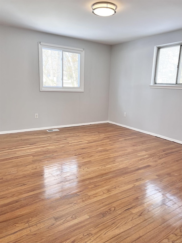 spare room with light hardwood / wood-style flooring and a wealth of natural light