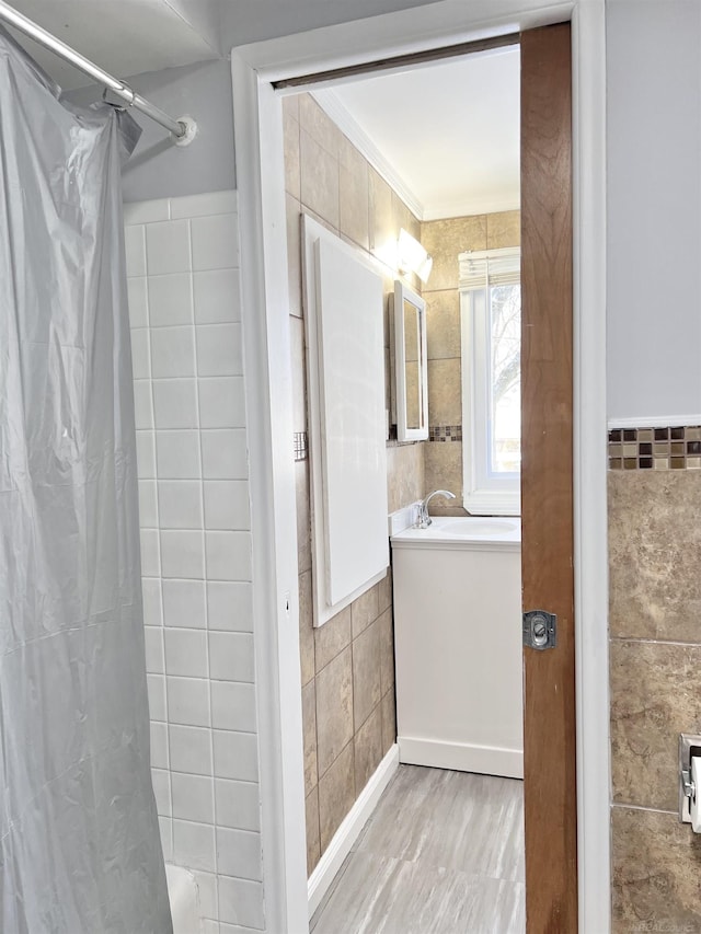 bathroom with crown molding, tile walls, and walk in shower