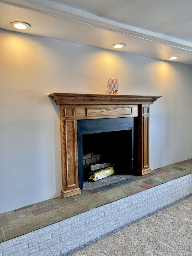 room details with carpet and a brick fireplace